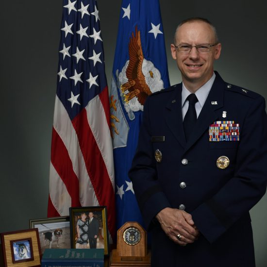 Pictured is the official Air Force Medical Service Corps chiefs portrait of Significant Sig and Brig. Gen. Jay Burks, FURMAN 1989, taken in July 2018. All chiefs have their portraits placed in the hallway of the Health Services Administration Course in Fort Sam Houston in San Antonio. Burks chose to include family photos of he and his wife, Valarie, their first beagle, Cody, and their current beagle, Jersey; a copy of the Well-Managed Community Hospital guidebook for health care administration; and an award for when Burks was named the Brig. Gen. Peter Bellisario Air Force Young Healthcare Administrator of the Year.