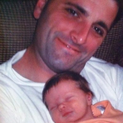 Brian Cudnik, OSWEGO STATE 1993, is shown holding his newborn daughter, Samantha, in 2003. Cudnik entered the Chapter Eternal in 2004.